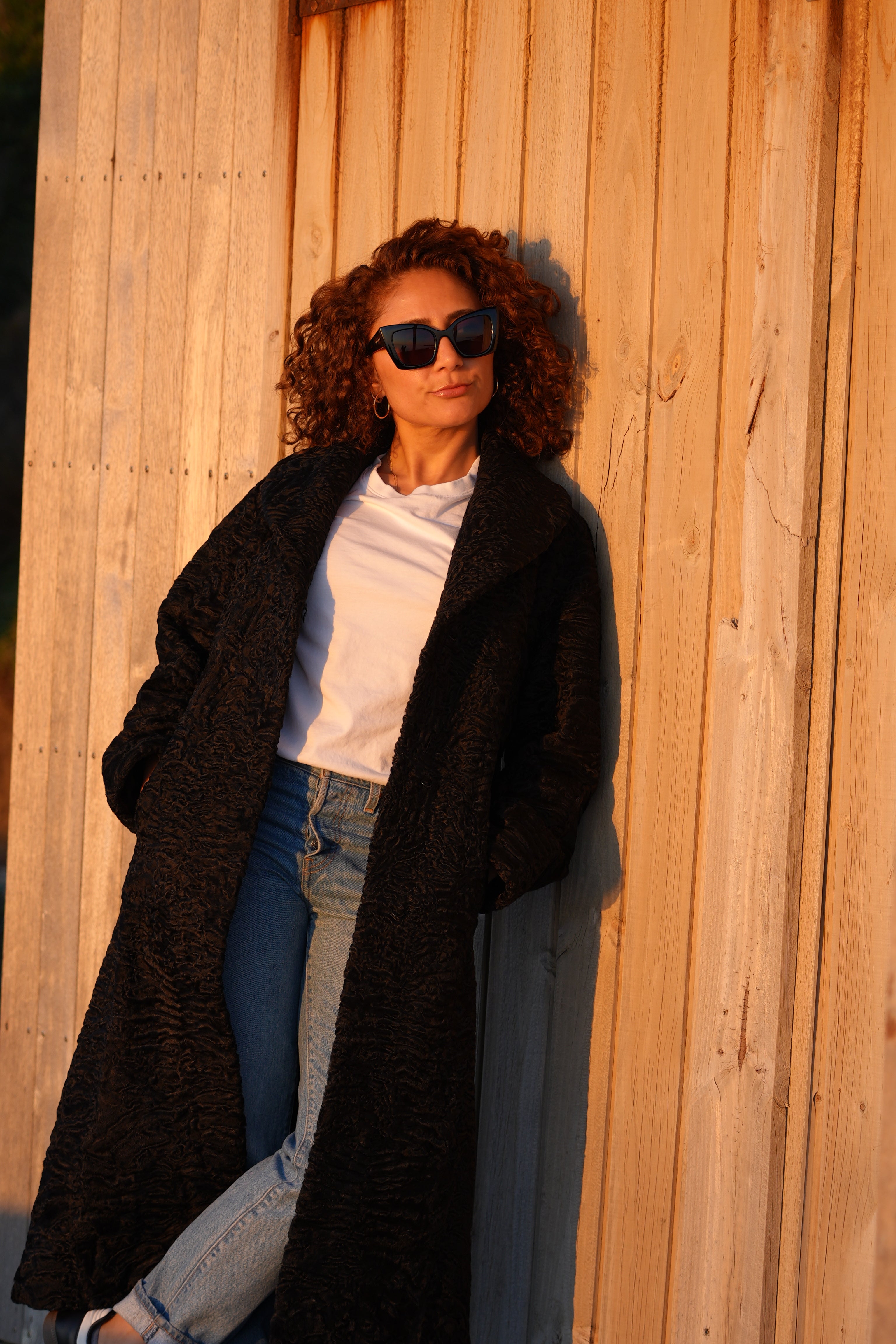 Black long karakul coat in the sun